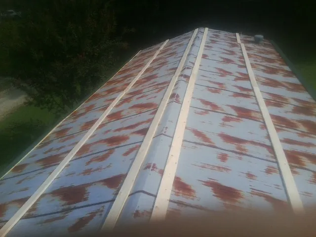 Rusted metal roof panels with new wood purlins before replacement — Storm Damage Roof Repair in Lincolndale by Roofing Brothers