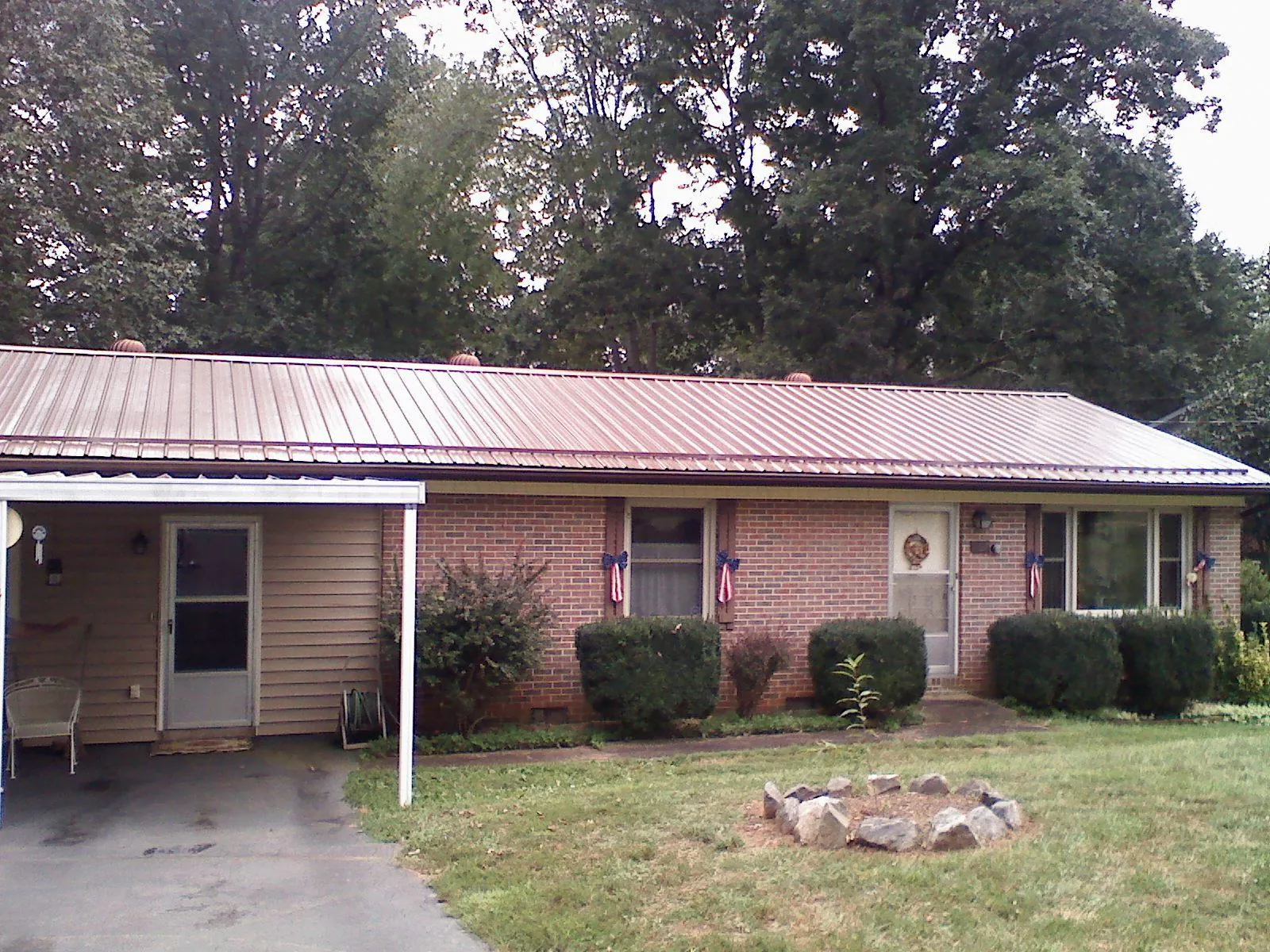 Bronze metal roof and carport on a brick ranch home — Roof Repair work by our crew in Lincolndale